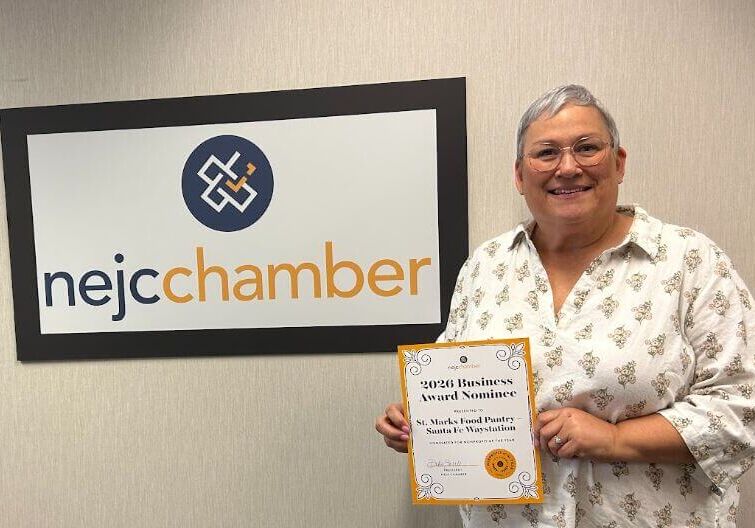Cindy Beals from Santa Fe Waystation in front of NEJC Chamber sign